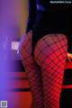 A woman in fishnet stockings is sitting on a table.