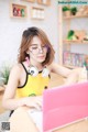 A woman sitting at a table with a laptop and headphones on.