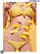 A woman in a yellow bikini with sticky notes on her body.