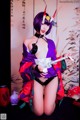 A woman in a purple and red kimono posing for a picture.